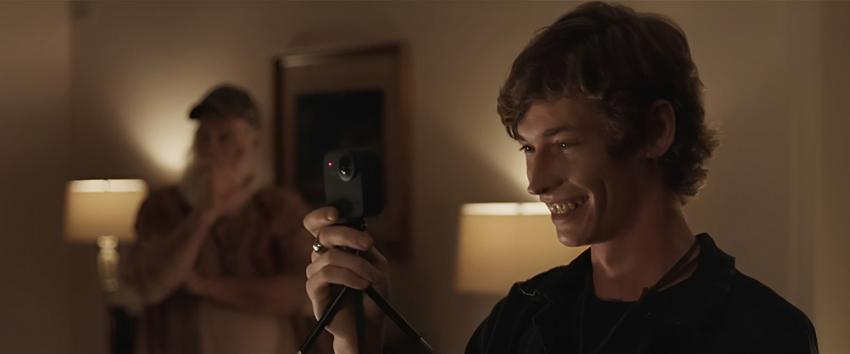 A House on the Bayou (1970) Movie scene: A smiling Isaac (Jacob Lofland) holding a camera, with Grandpappy (Doug Van Liew) standing in the background 