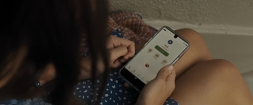 Afraid (1970) Movie scene: A shot of someone holding a phone displaying the contact details for AIA