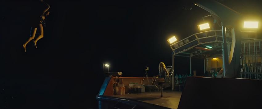 Dangerous Animals (1970) Movie scene: A woman being lifted by a winch and dangled overboard at night.