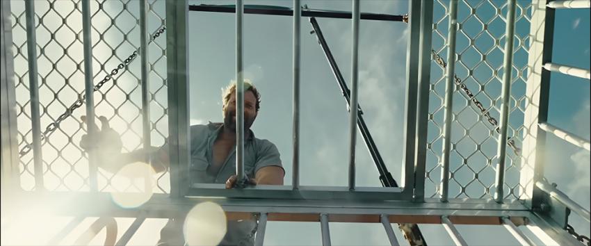 Dangerous Animals (1970) Movie scene: Low-angle shot of Bruce Tucker (Jai Courtney) closing the shark cage door