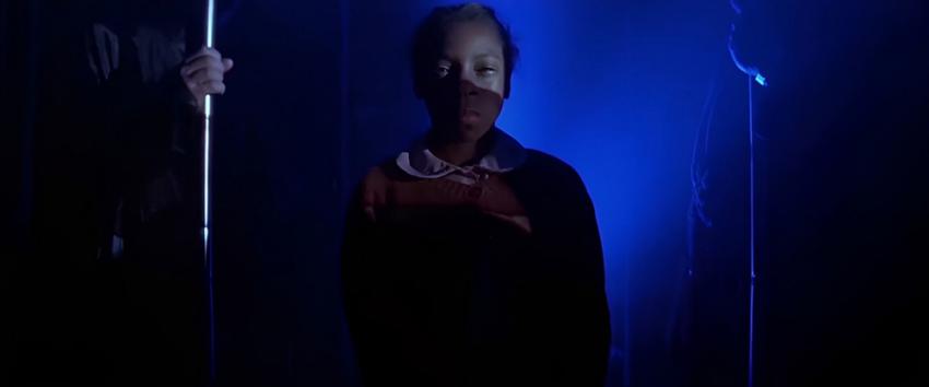 Flatliners (1970) Movie scene: A child surrounded by an eerie blue light, creating a foreboding atmosphere
