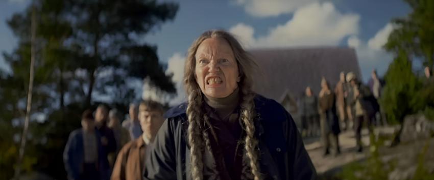 Get Away (1970) Movie scene: The custodian, Klara (Anitta Suikkari), with long braided hair, stands in front of a group of people