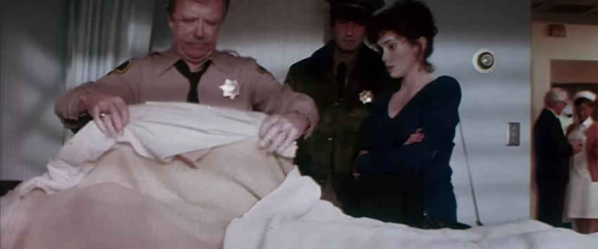Halloween III - Season of The Witch (1970) Movie scene: A police officer lifts a hospital sheet to reveal a dead body to Ellie (Stacey Nelkin).