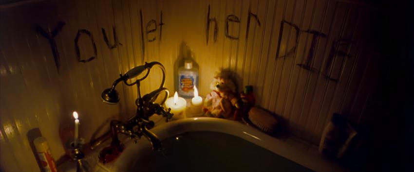 Hide and Seek (1970) Movie scene: The edge of a bathtub with lit candles, and the words "You Let Her Die" written on the walls