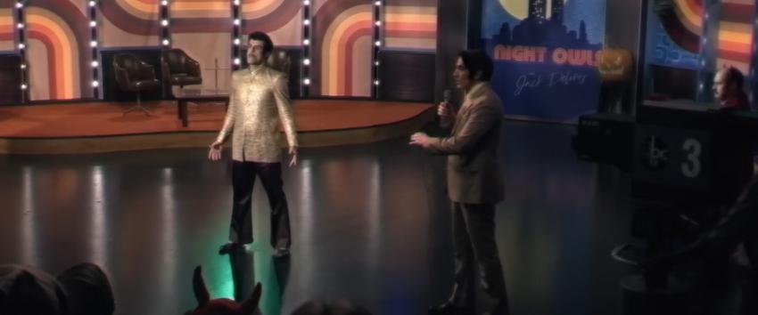 Late Night with The Devil (1970) Movie scene: Christou (Fayssal Bazzi) and Jack Delroy (David Dastmalchian) center stage on Night Owls