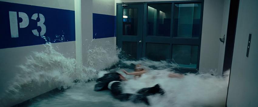 P2 (1970) Movie scene: Angela (Rachel Nichols) and a man are knocked to ground as a surge of water crashes over them