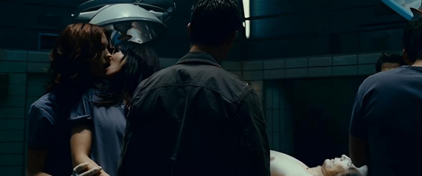 Pathology (1970) Movie scene: Two women, one with reddish-brown hair and the other with dark hair, kissing passionately.