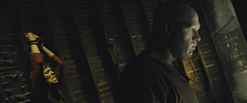 See No Evil (1970) Movie scene: Jacob Goodnight (Glenn Jacobs) stands menacingly, staring through a window while Kira (Samantha Noble) is tied up behind him