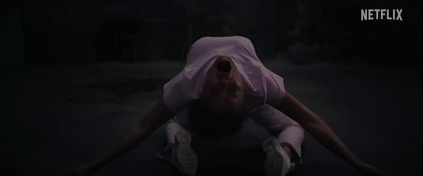 The Deliverance (1970) Movie scene: Person contorted in a possession-like pose, with their back arched and head tilted upward in a haunting, unnatural manner