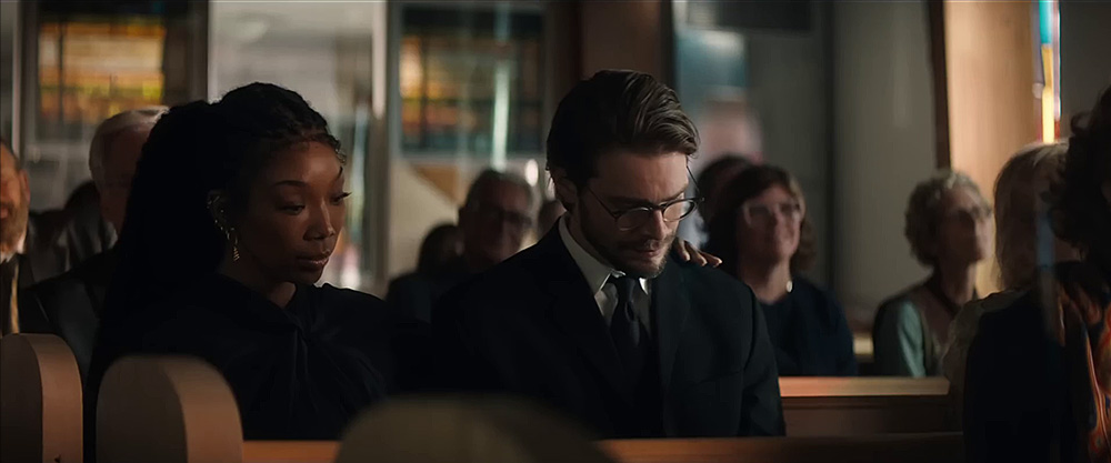 The Front Room (1970) Movie scene: Belinda (Brandy Norwood) and Norman (Andrew Burnap) sit together, dressed in black, during a church ceremony