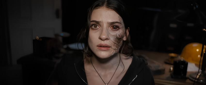 Until Dawn (1970) Movie scene: Clover (Ella Rubin) with possession overtaking the left side of her face, showing a dark transformation.
